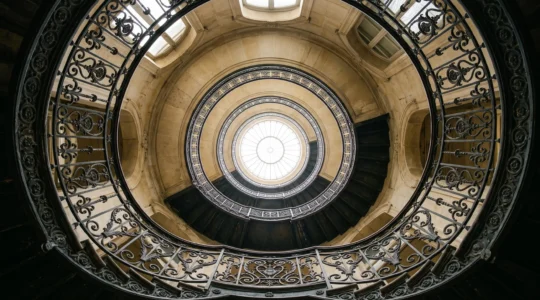 Escalier en colonne ascendant vers une verrière lumineuse, symbolisant la progression organique d'un site vers la premiere page de Google sans backlink externe